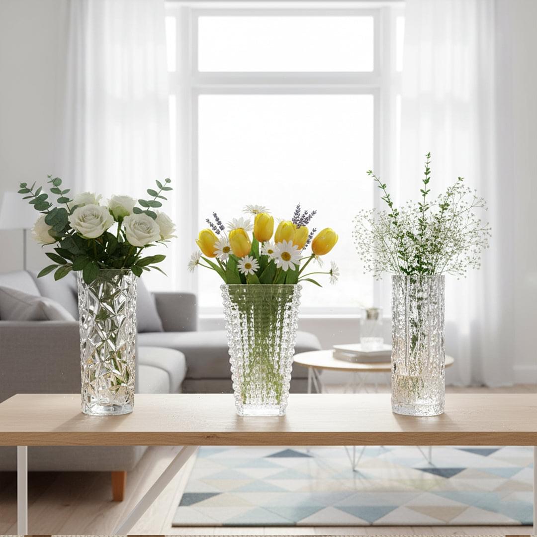 Three clear glass vases with faceted diamond and grid textures, displayed with flowers