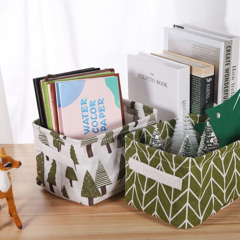 Green leaf-and-tree patterned fabric storage baskets with handles, on shelf