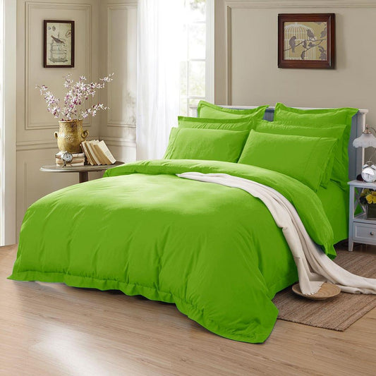 Green duvet quilt cover set with two pillowcases and draped throw on bed