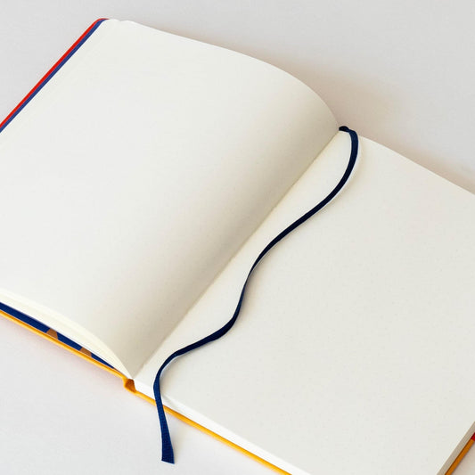 Open notebook with white pages and dark blue elastic band binding