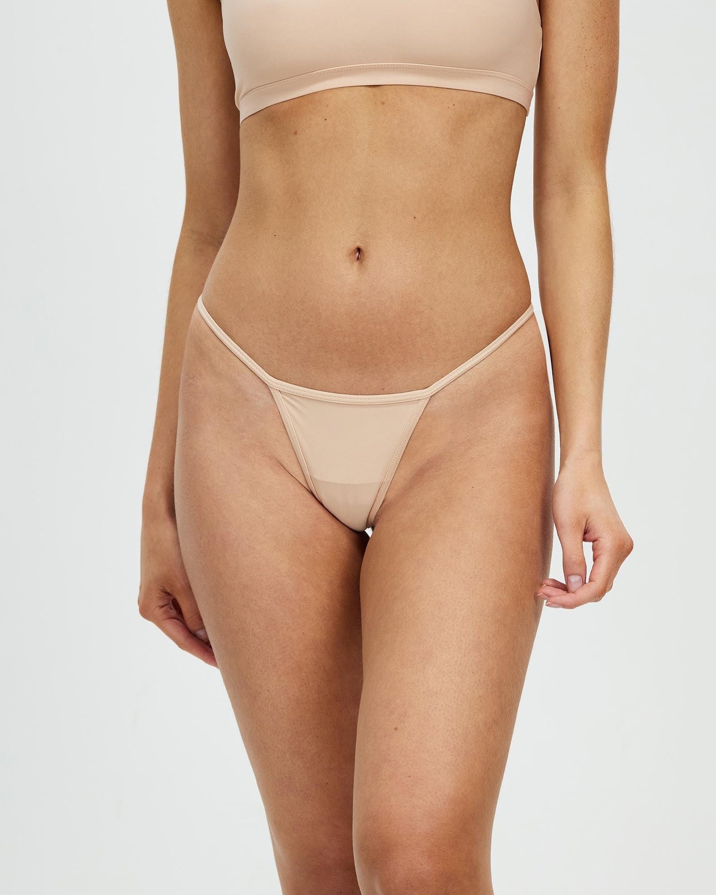 Women's bone-colored mesh thong with V-cut front and low-rise waistband