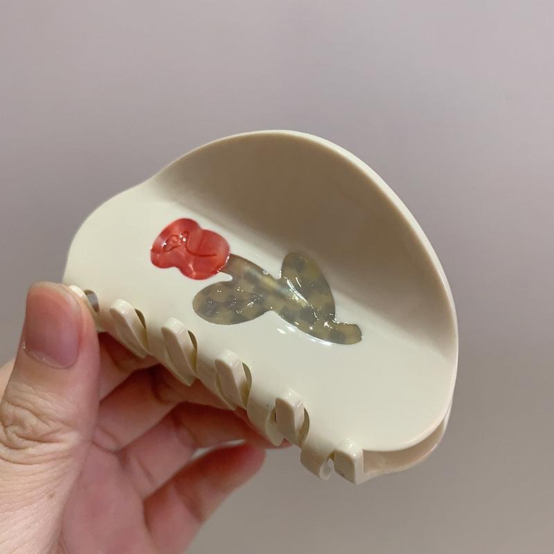 Medium white hair claw clip in hand with red rose flower center and teeth
