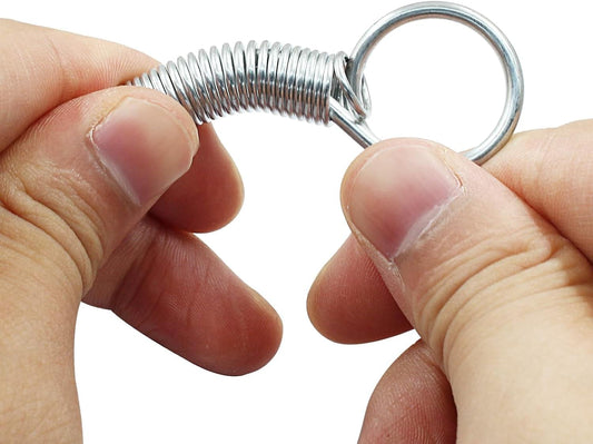 Metal spring latch hook with circular ring, held in fingertips.