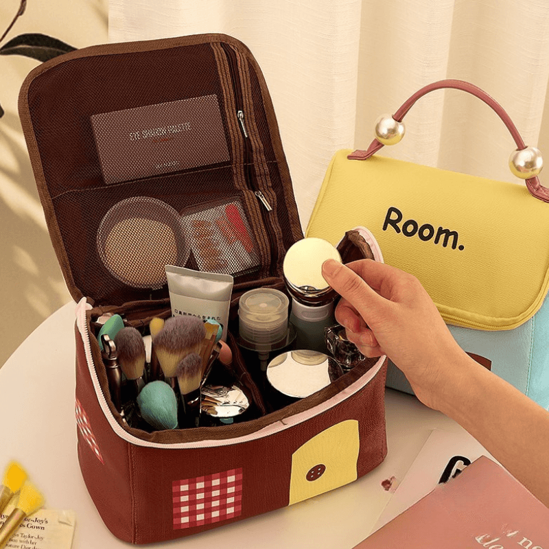 Cosmetic makeup bag with zipper open top, makeup brushes inside (brown and yellow/blue).