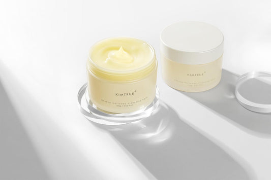 KIMTRUE cleansing balm in white jars, open jar with pale yellow cream swirl