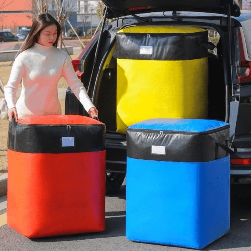 Two extra-large storage bags in a vehicle trunk, red and blue with black lids