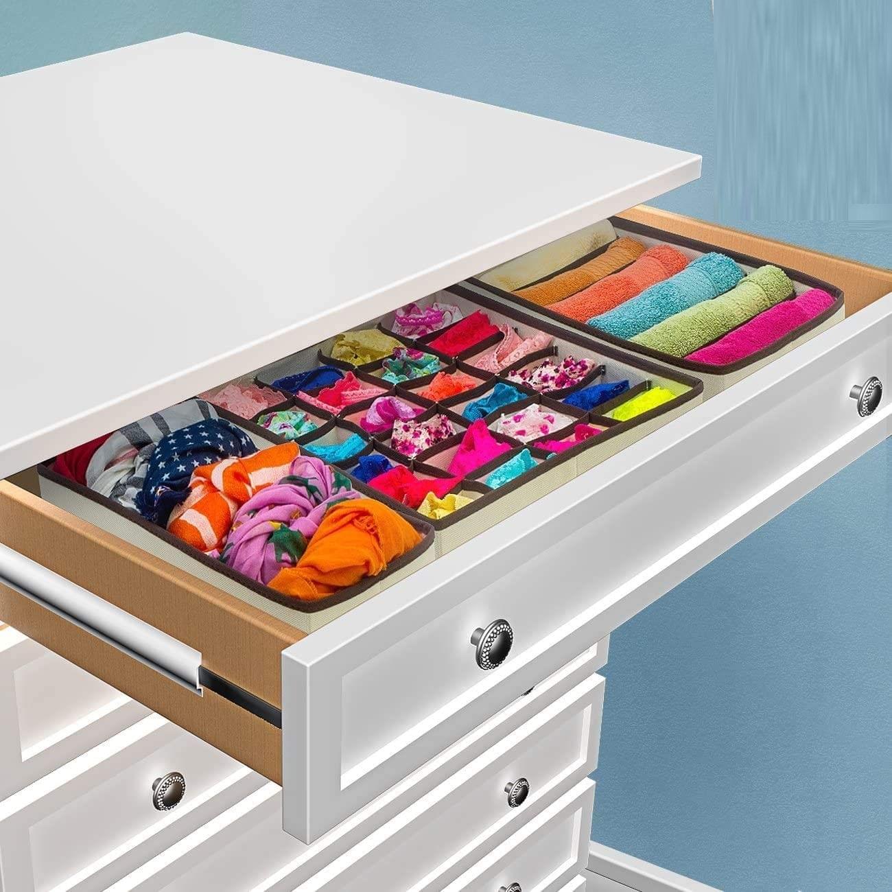 Black drawer divider boxes in a drawer with fabric-filled sections