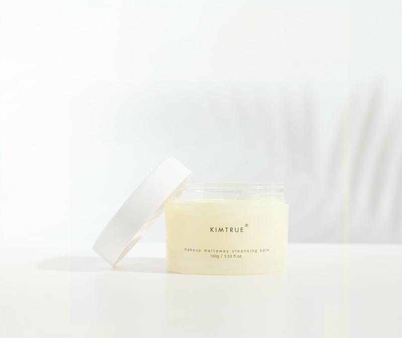 KIMTRUE cleansing balm jar with open lid, pale yellow balm in see-through container