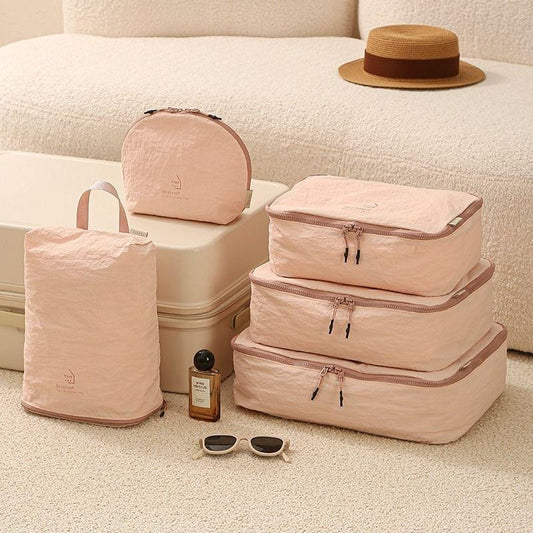 Light pink travel organizer set with packing cubes, cosmetic pouch, and shoe bag