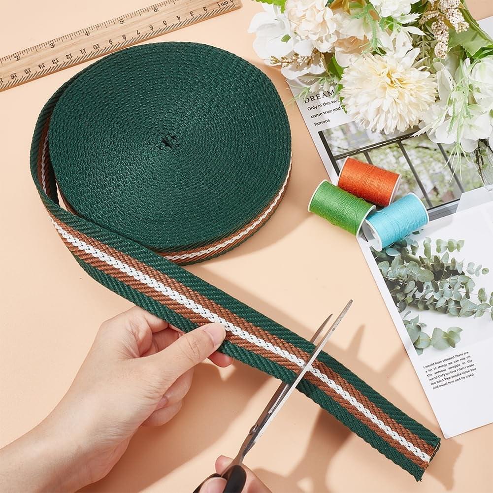 Olive green arrow jacquard ribbon trim with white and brown stripes, laid with scissors