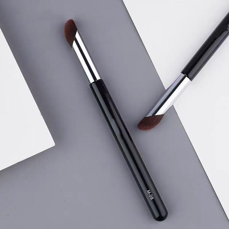 Two concealer brushes shown with black handles, silver ferrules, and brown bristles