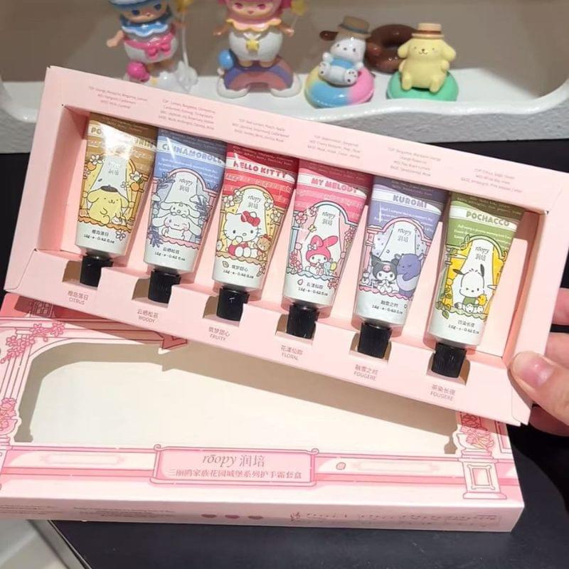 Open hand cream gift set with six tubes in a pink tray, shown by a hand