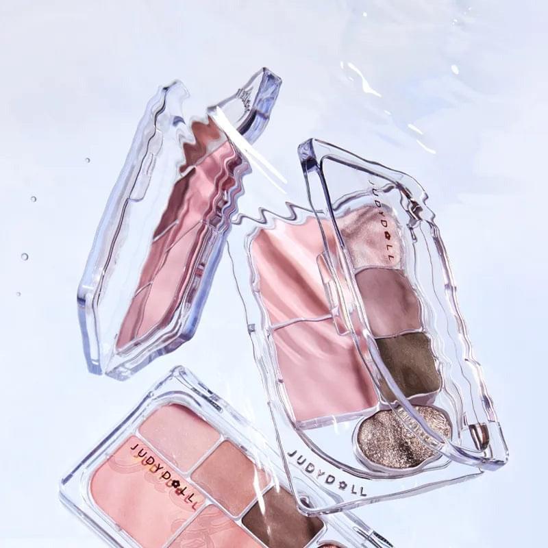 Set of clear compact eye shadow palettes with peach, brown, and pearl shades