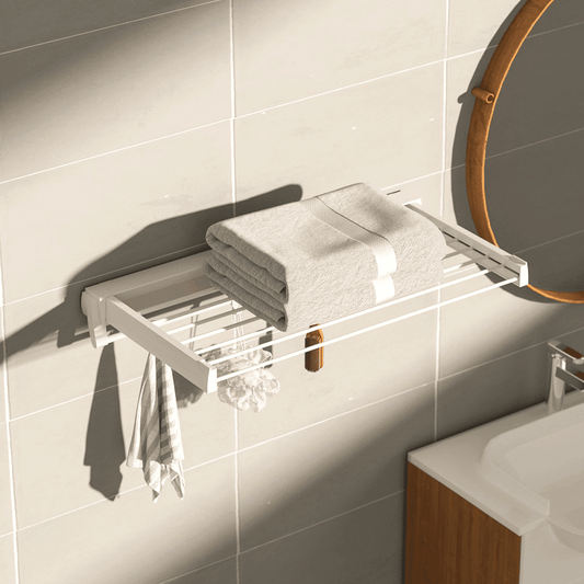 White wall-mounted drying rack holding folded towels and clothes with side frame