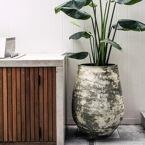 Anfernee planter vase with textured gray stone look and green leaves