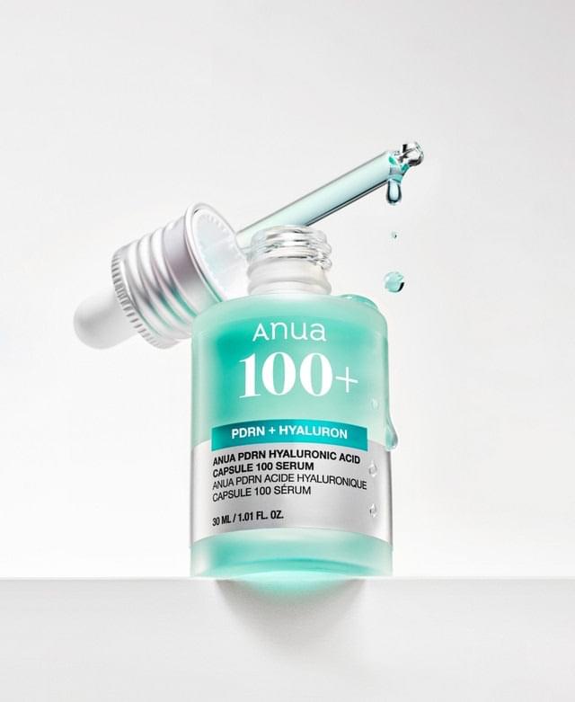 Anua 100+ hyaluronic serum bottle with silver pump top, teal liquid splash