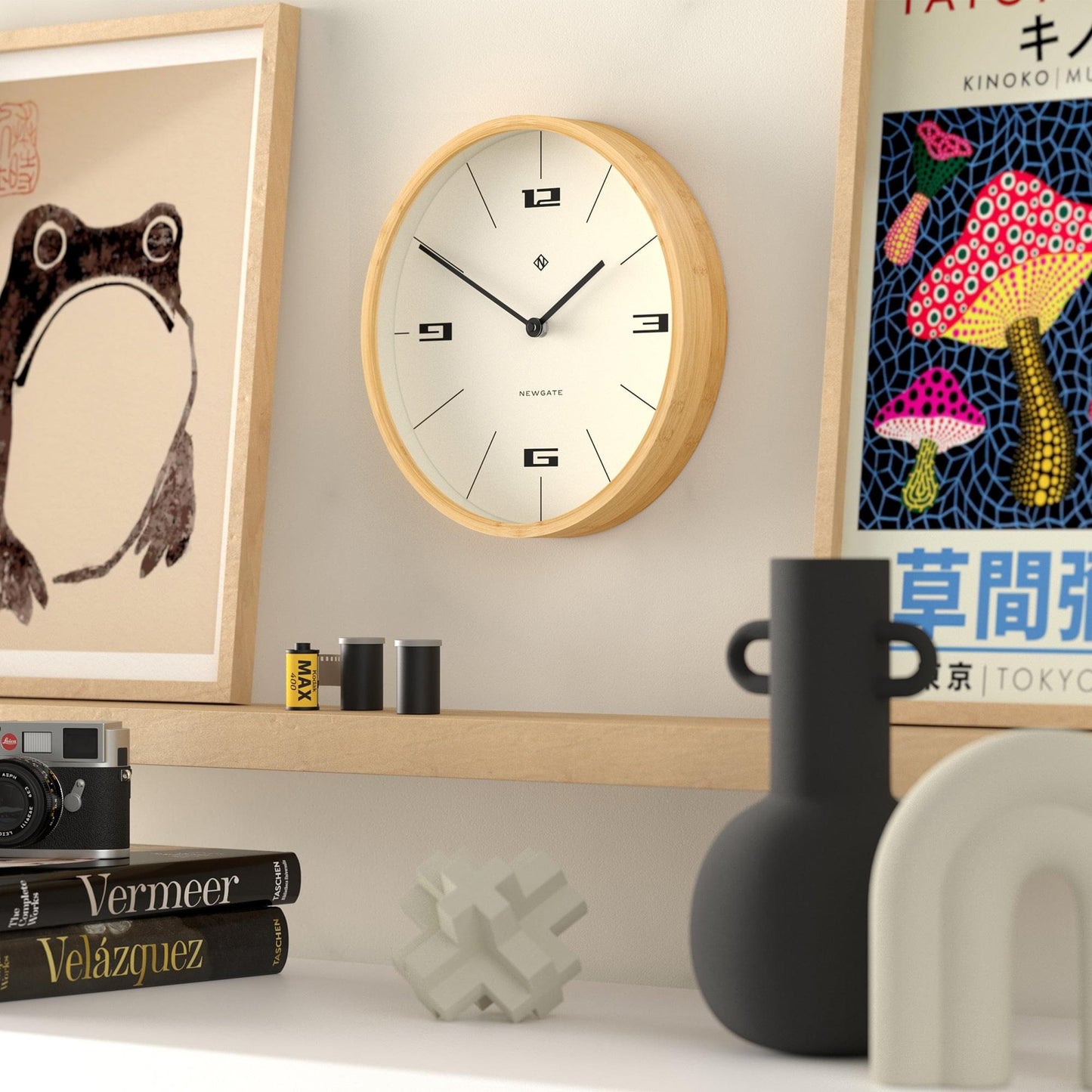 Wood-framed wall clock on a wall with cream dial, black hands, and numeral markers