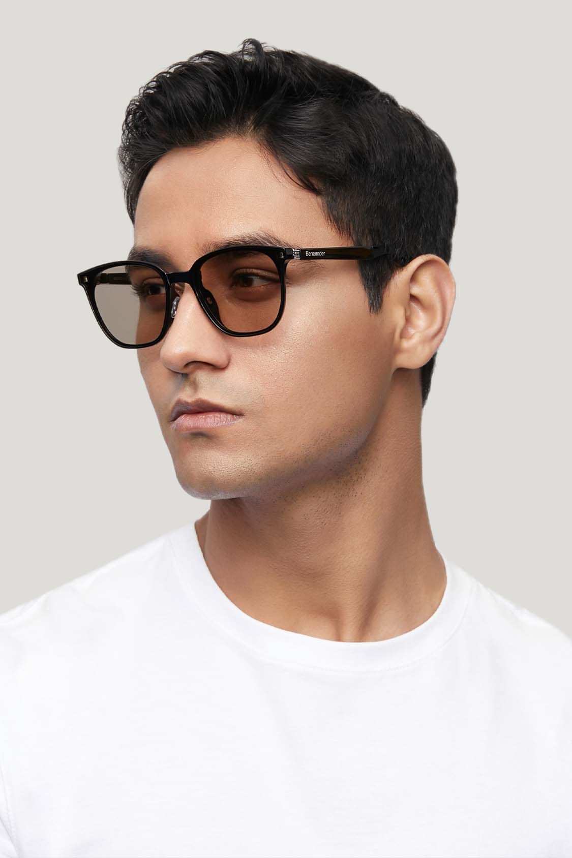 Rectangular dark sunglasses with black frames, side view on model