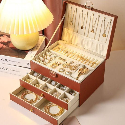 Brown lockable jewellery box with open lid and three-tier drawers for rings and earrings.