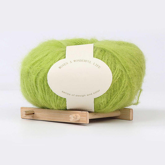 Green mohair yarn ball with centered label on small wooden base
