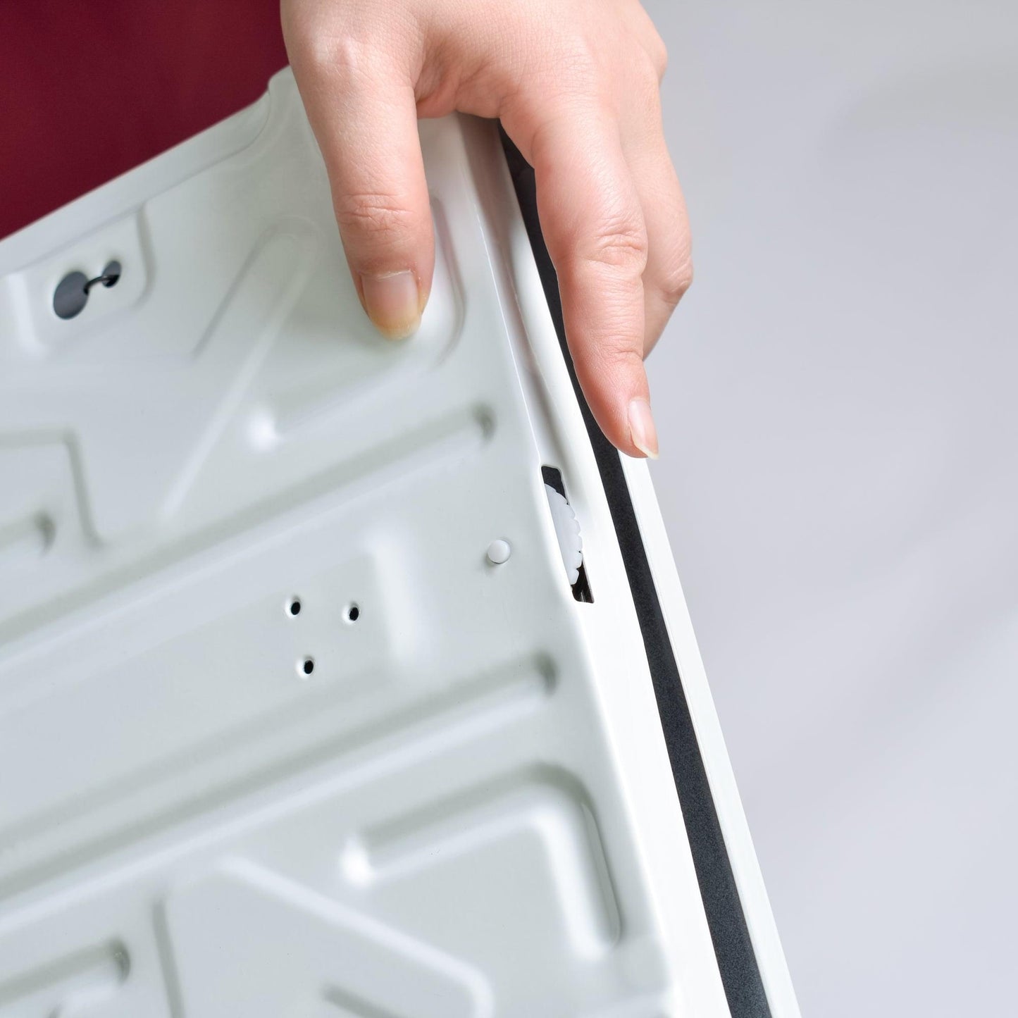 Bathroom scale underside with hand grip edge and panel openings
