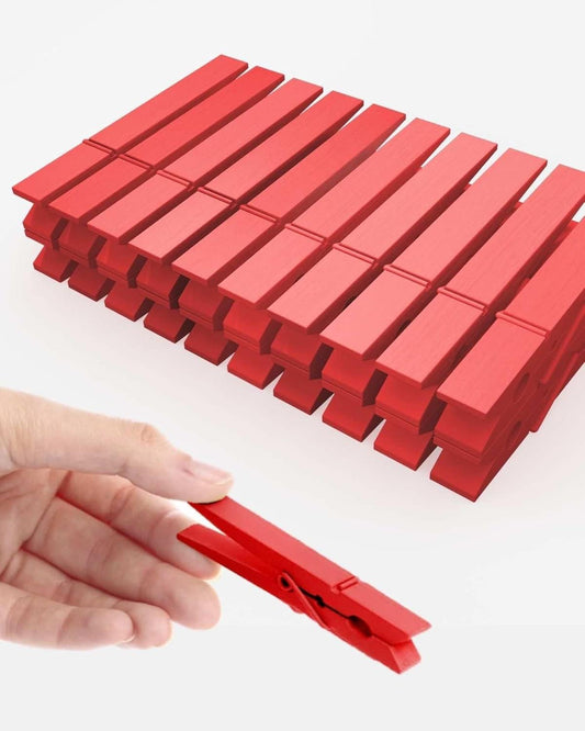 Red wooden clothespins, multiple spring clips with a hand holding one