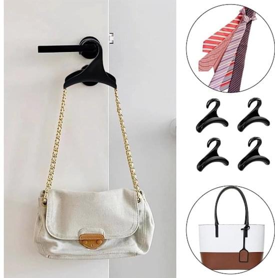 Black handbag hooks holding a white shoulder bag on a wall hook bar