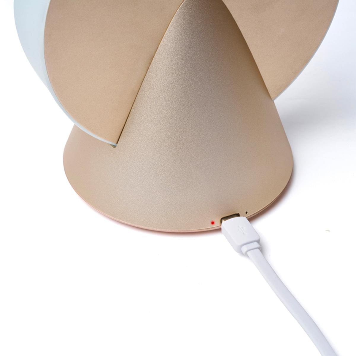 Portable LED lamp closeup: gold base with charging port and white USB cable