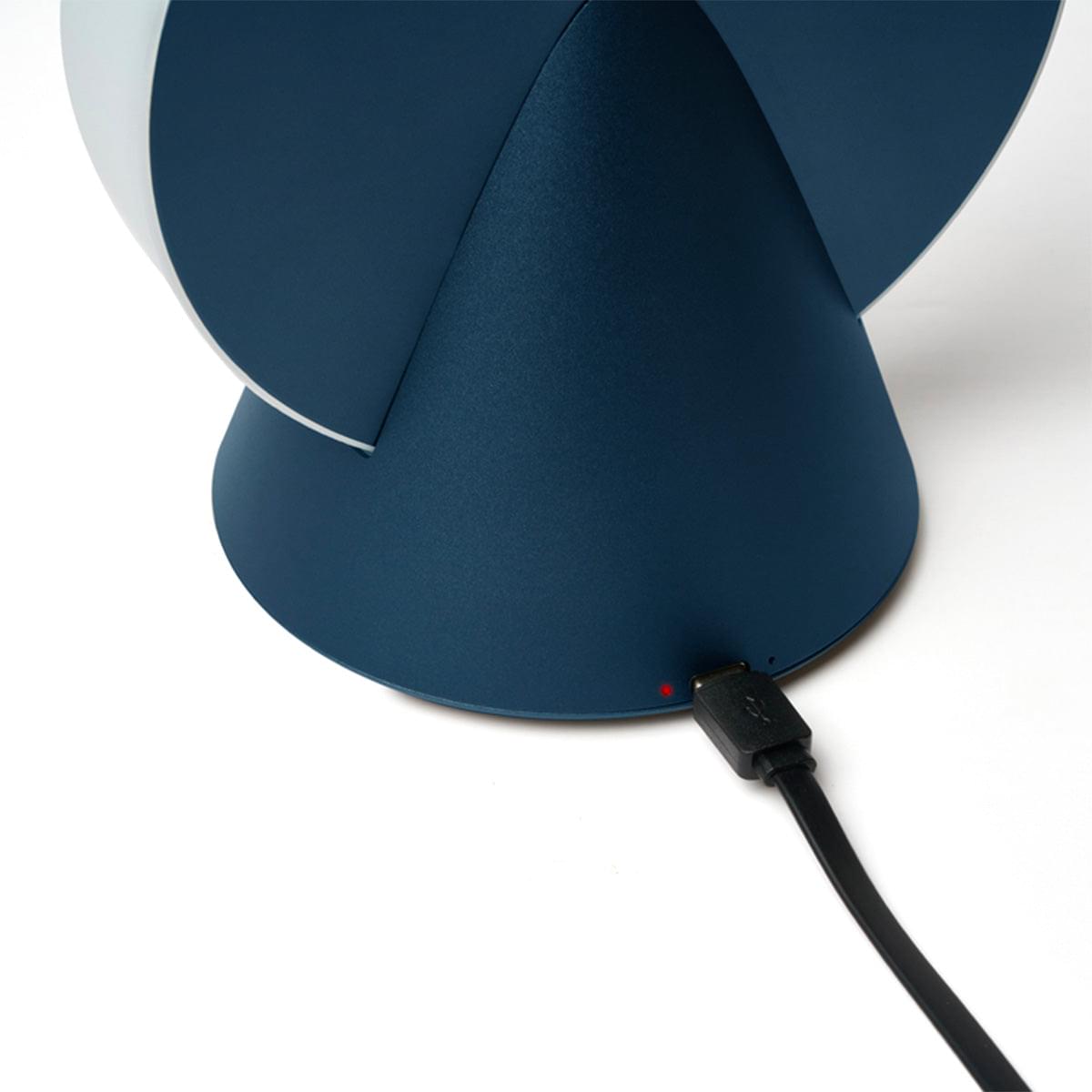 Blue conic portable LED lamp with visible charging cable plugged into the base