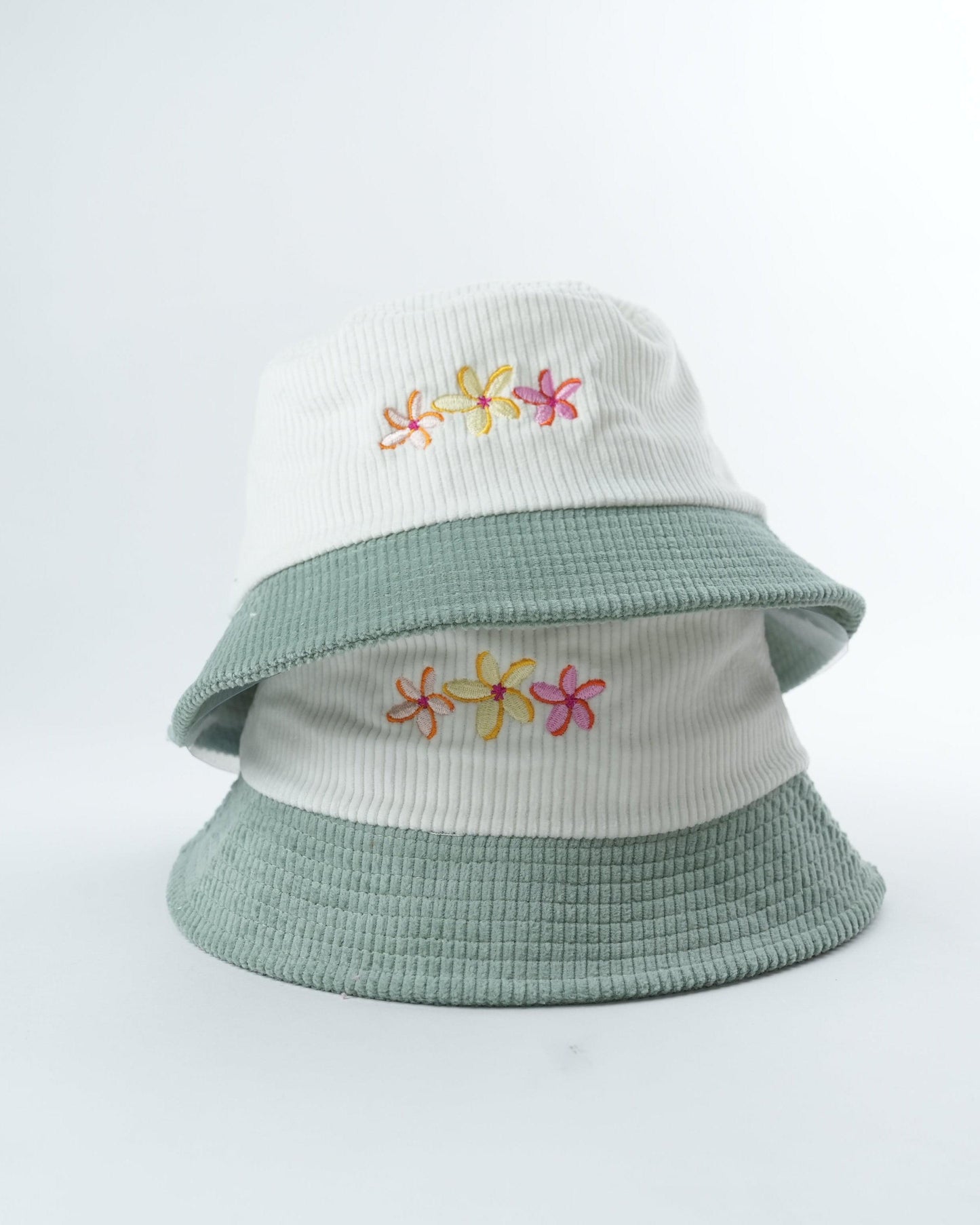 Two-tone bucket hat with flower embroidery on crown and side brim, cream top and sage green