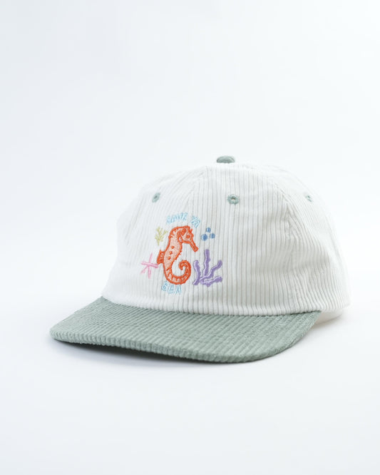 White ribbed baseball cap with light green brim and seahorse patch
