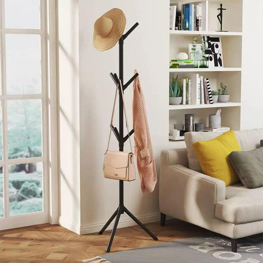 Floor clothes and hat rack with black stand holding a hat, coat, and small bag