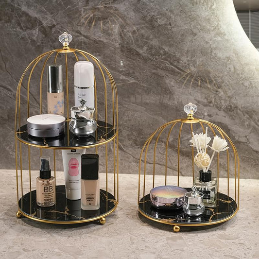 Two-tier birdcage organizer with gold frame holding bottles, jars, and makeup