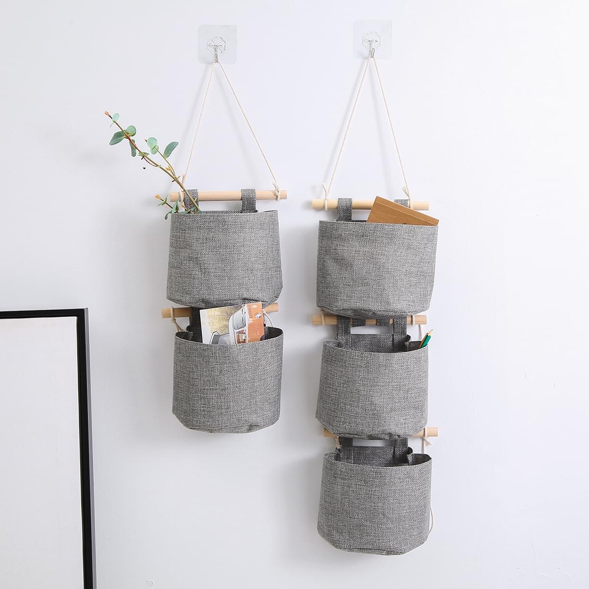 Two gray hanging storage bags with three pockets each and top straps