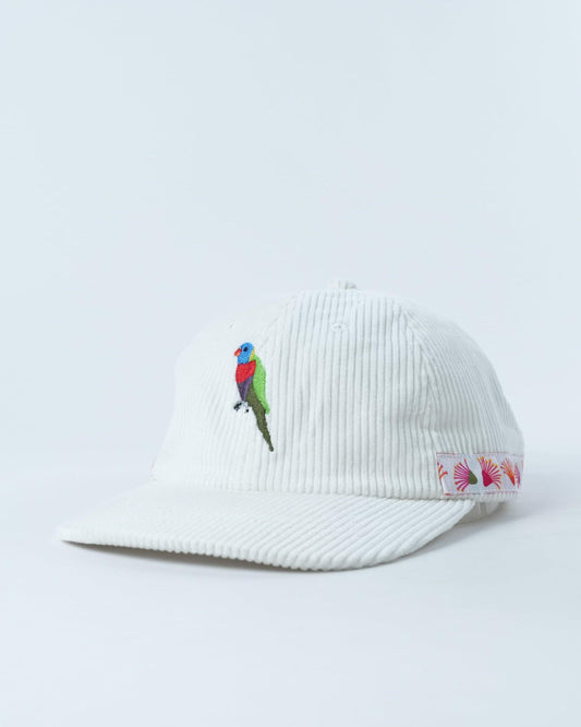 White ribbed cap with embroidered lorikeet and floral fan print on brim