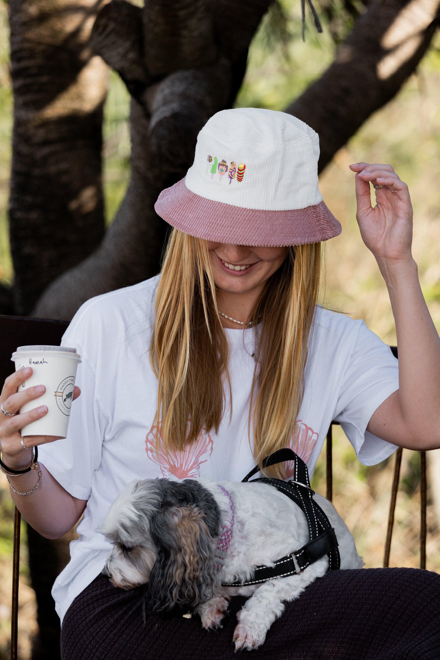 Two-tone bucket hat on wearer, white knit crown and mauve brim with small logo patch