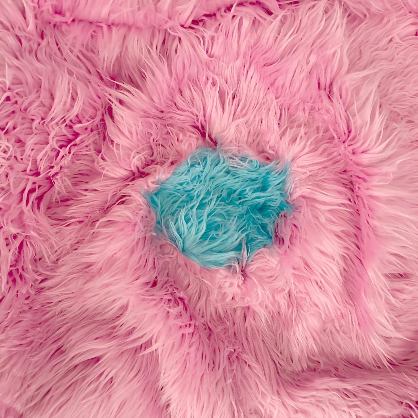 Rainbow ombre faux-fur bean bag close-up, blue center visible inside the bean opening