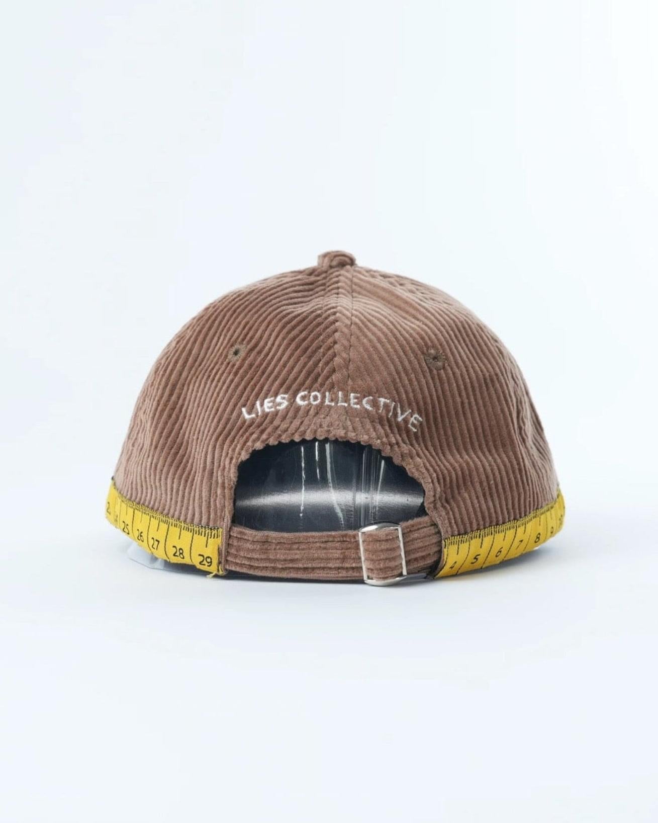 Brown corduroy mini lid cap with embroidered lettering and yellow brim label