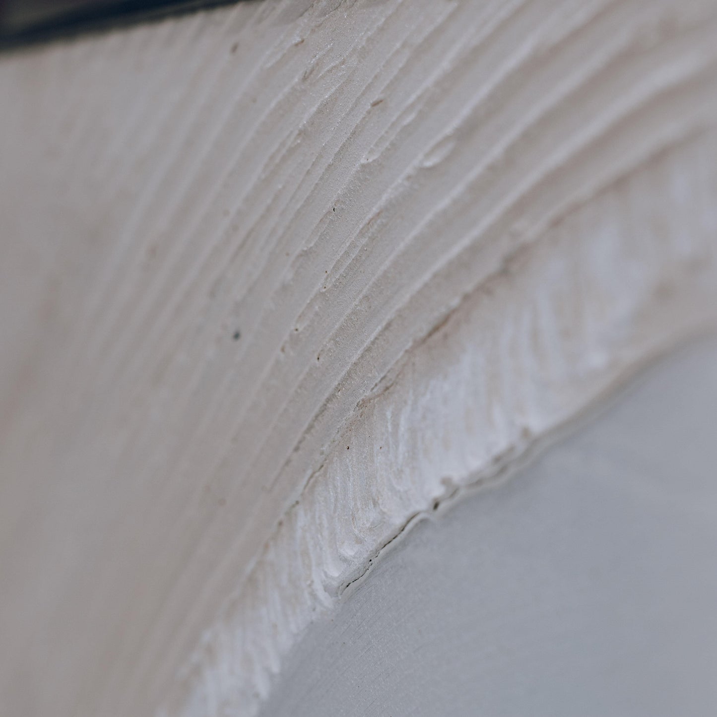 Dimensional sand art texture close-up with raised white sand lines and faint tan streaks