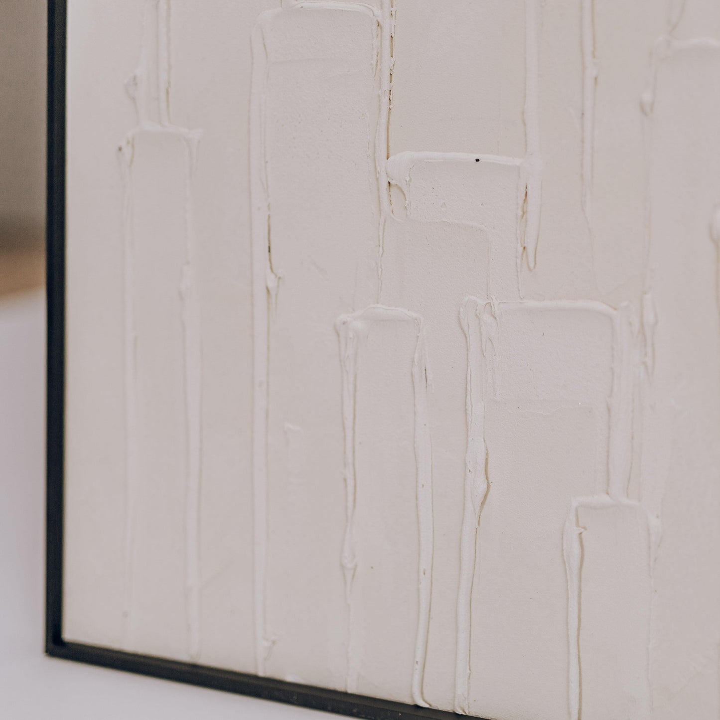 Framed dimensional sand art detail with off-white raised blocks and lines