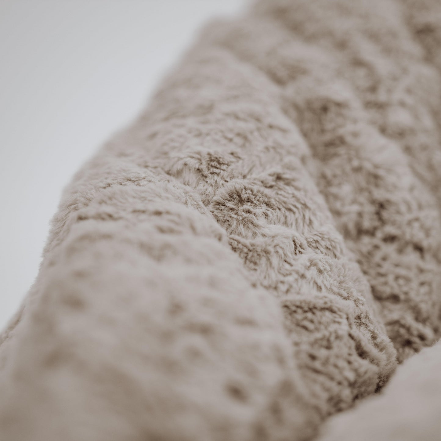 Close-up of champagne latte plush shag fabric on mini beanbag chair