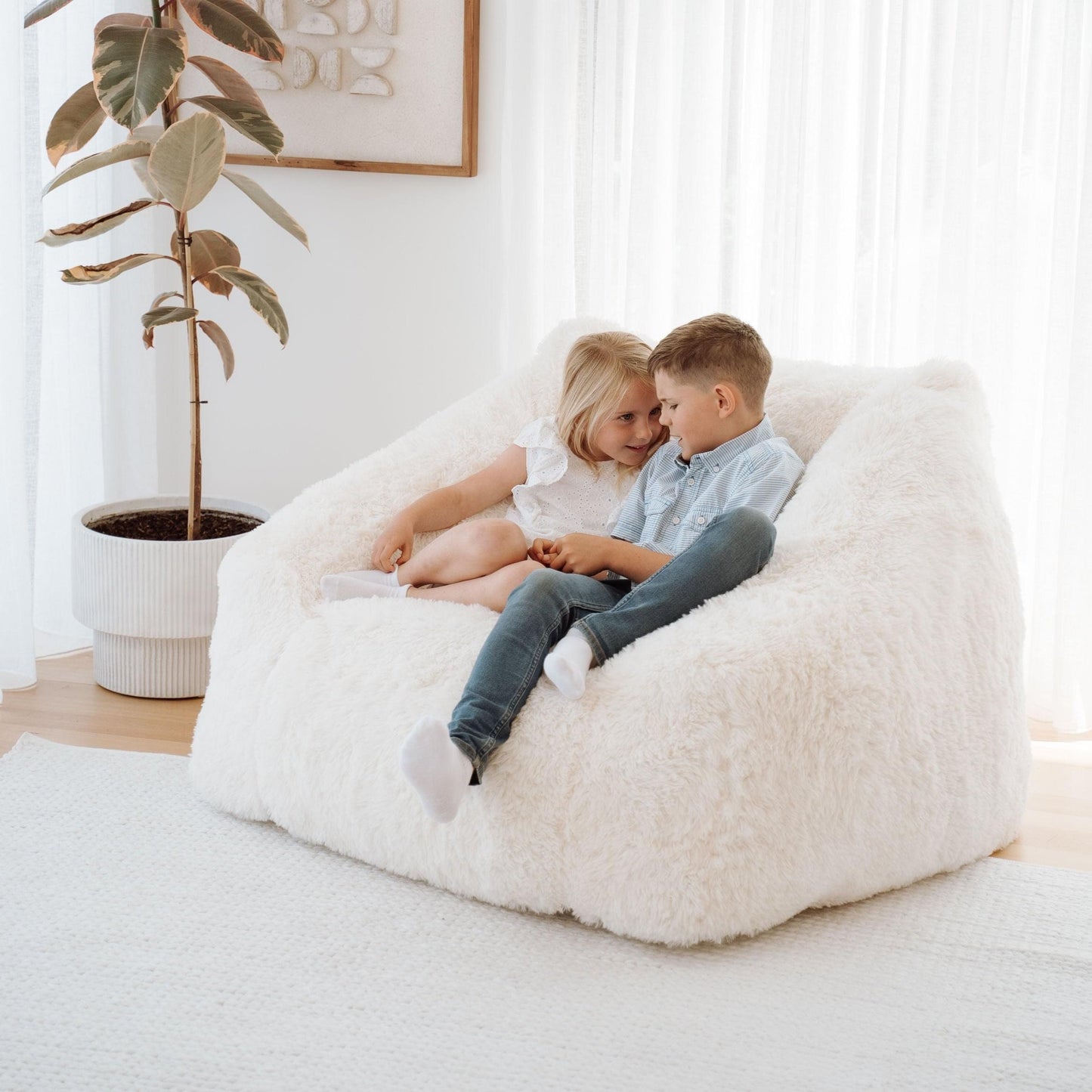 Cream plush bean bag lounger with two children sitting together