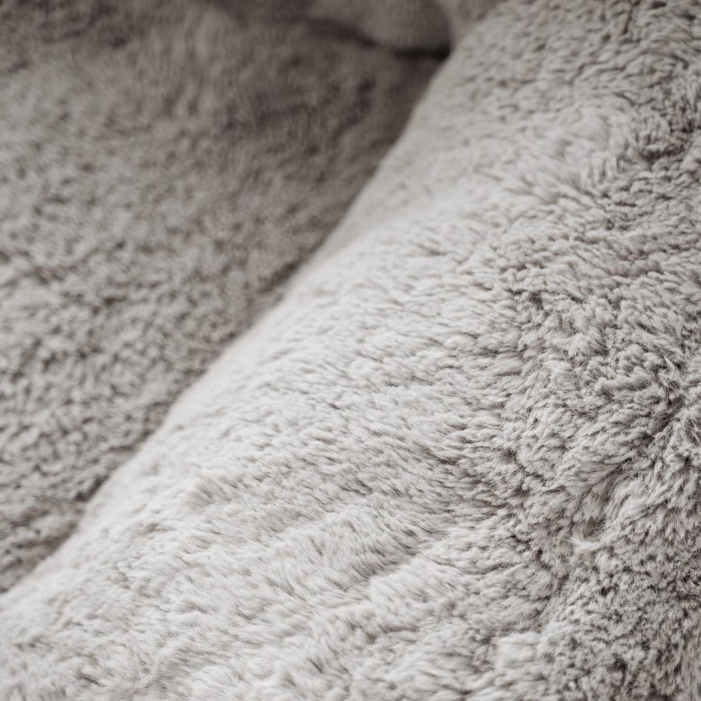 DreamPod® chair upholstery close-up, soft gray shaggy faux-fur fabric