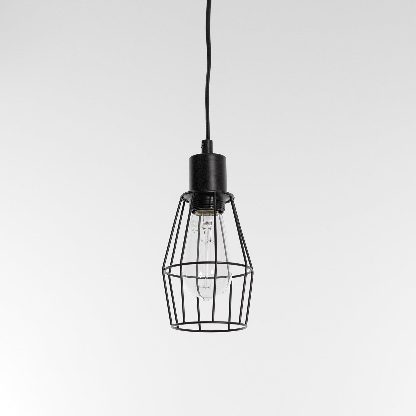 Black industrial cage pendant light with clear bulb hanging on cord