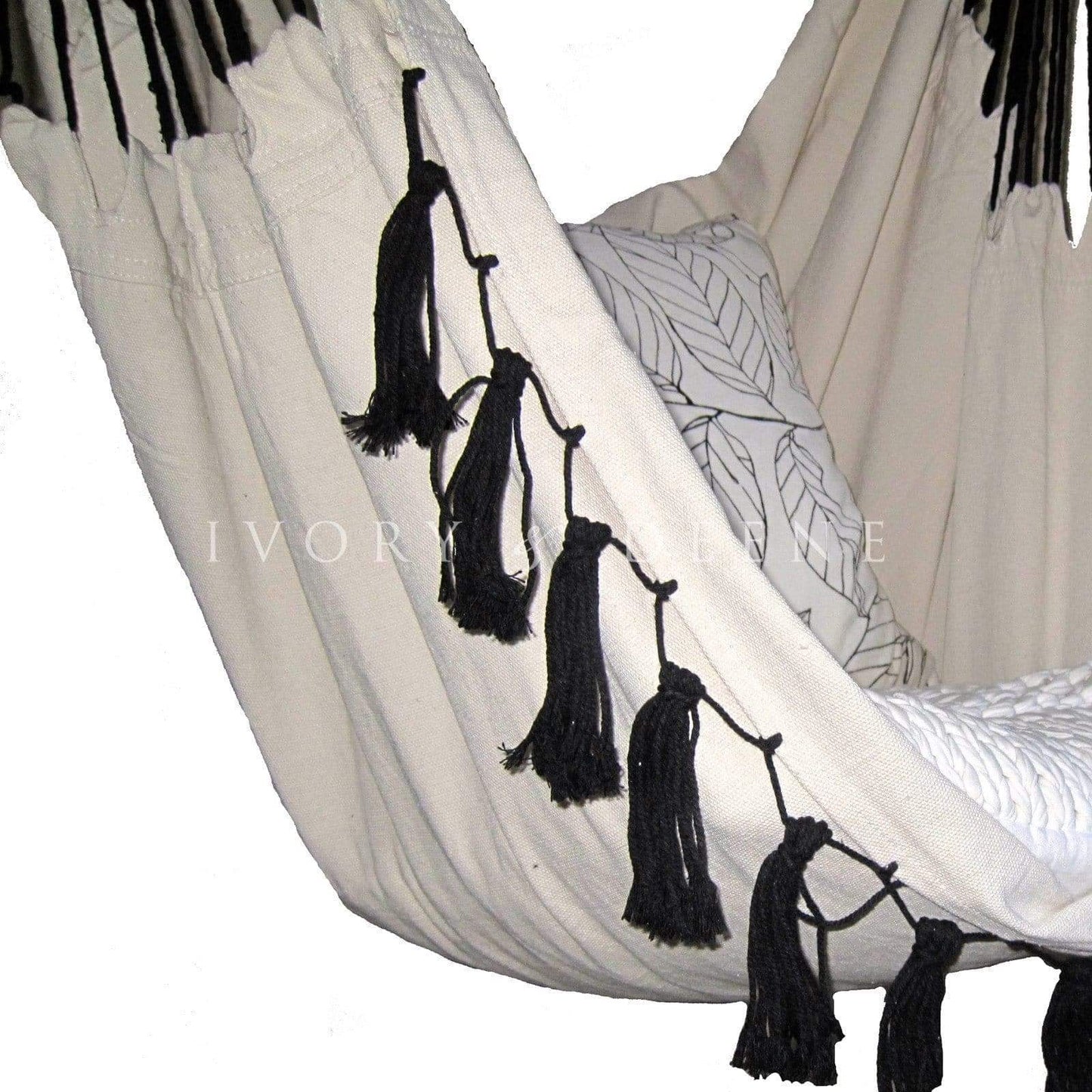Close-up of cream hammock chair fabric with black tassel fringe along edge.