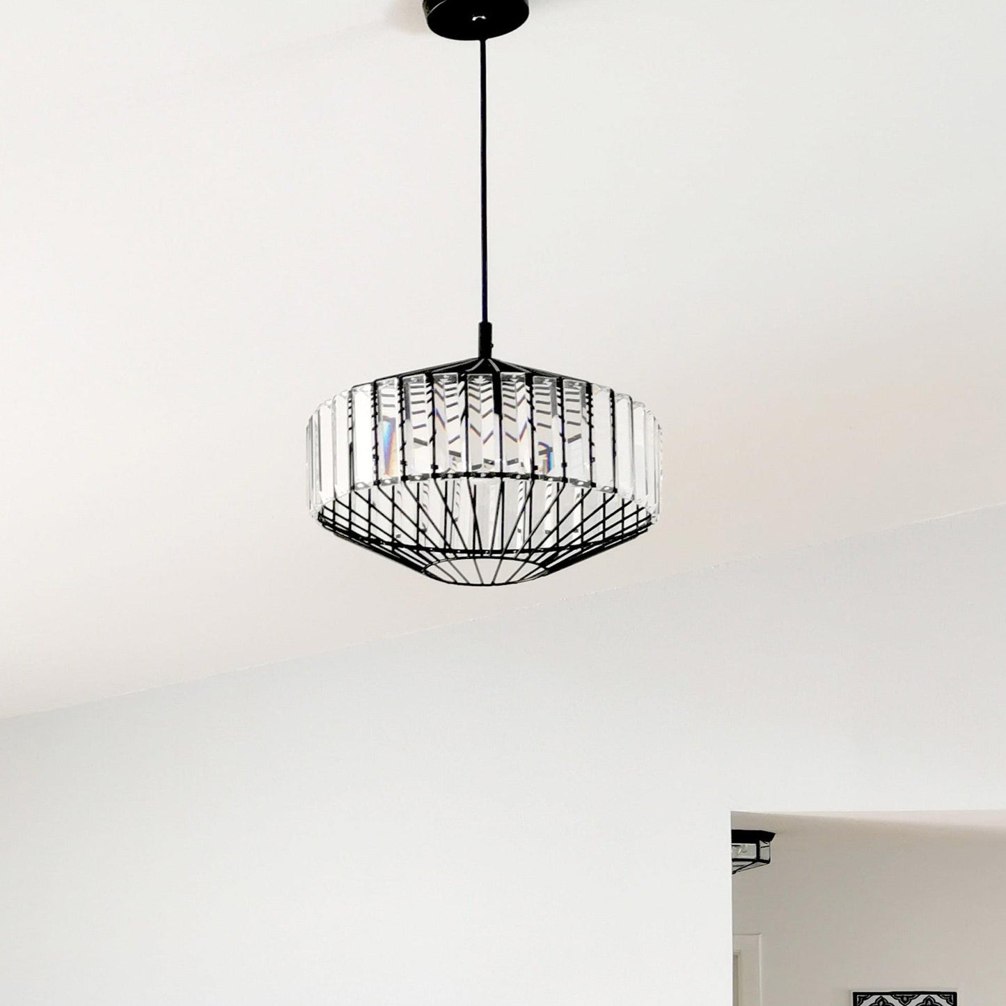 Black prism glass pendant light hanging from black cord with ribbed glass shade