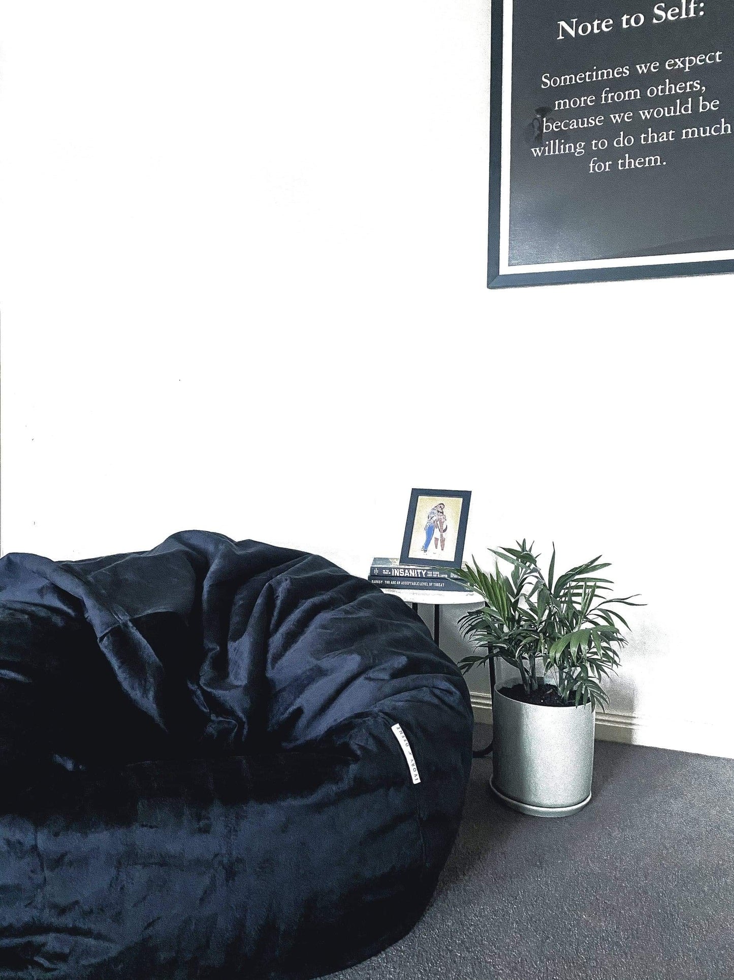 Dark bean bag chair with plush fabric cover and visible tufted seam lines
