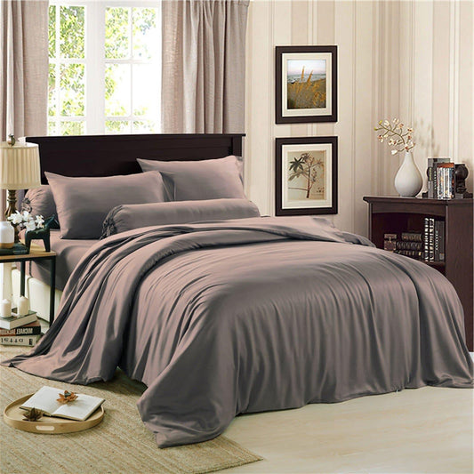 Charcoal grey bedding set on bed: duvet cover, fitted sheet, and matching pillowcases