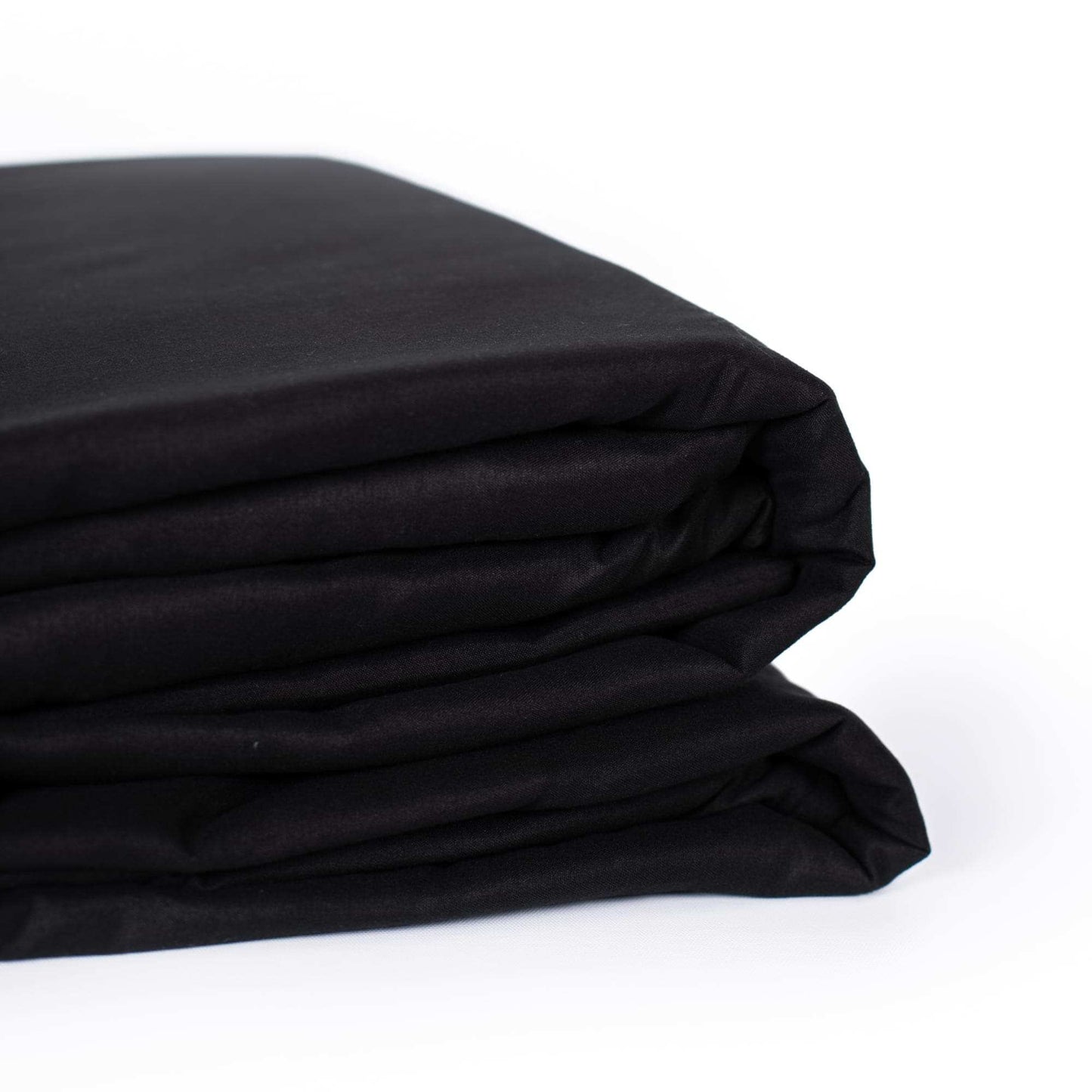 Close-up of folded black sheet fabric, smooth surface and creases