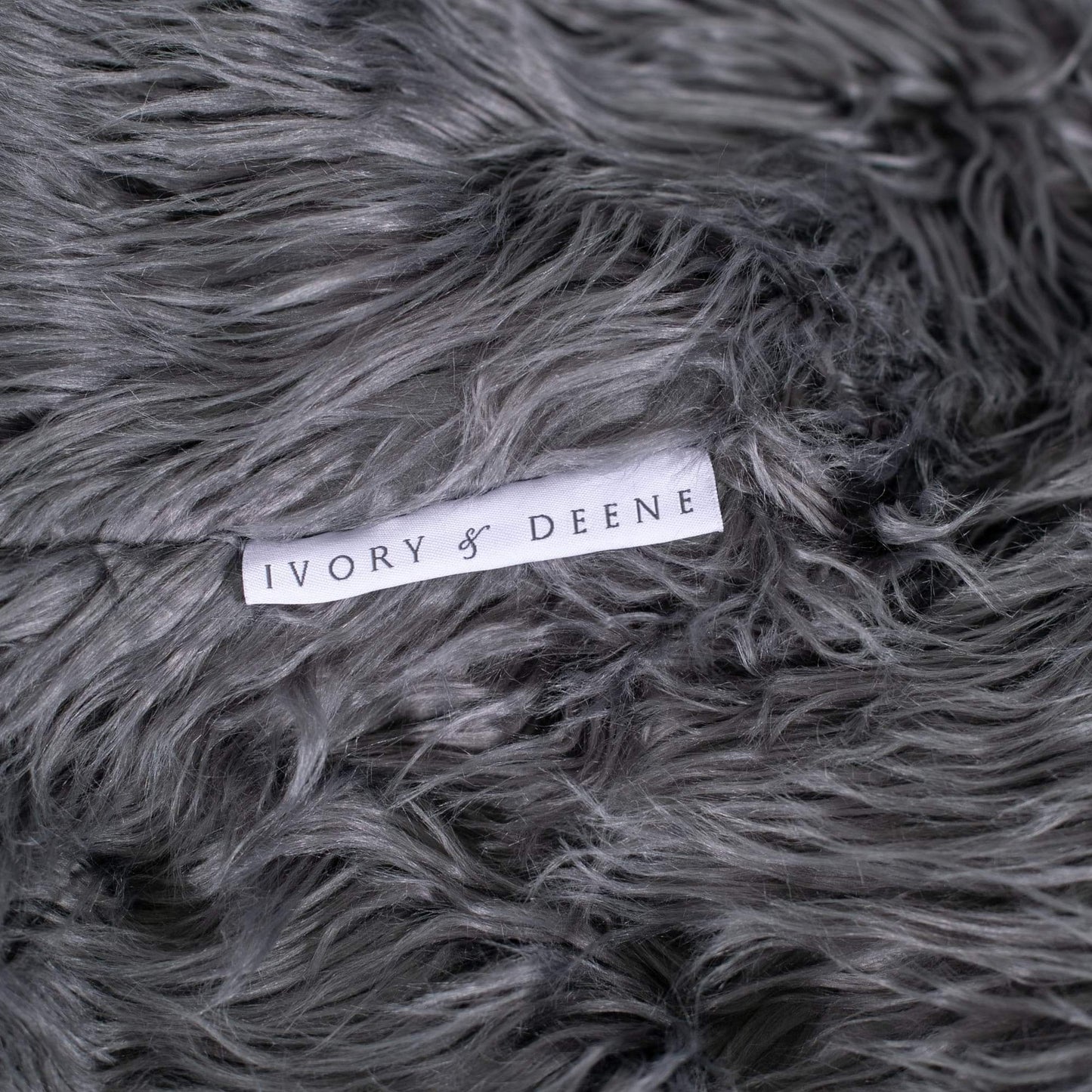 Charcoal faux-fur bean bag close-up with IVORY & DEENE fabric tag